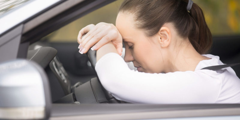 Young woman talking on her phone driving a car Careless driver woman talking on her cell phone while operating a car, multi task. Young woman staying in touch with family and friends, or conducting business